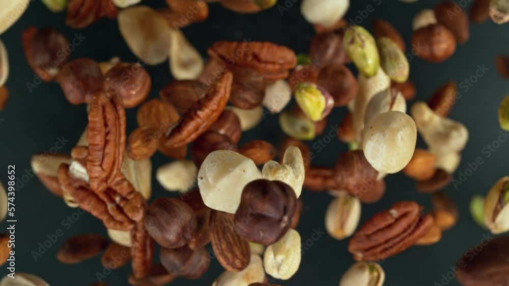 Poster super slow motion of rotating mix nuts up to the air. filmed on high speed cinema camera, 1000fps, p