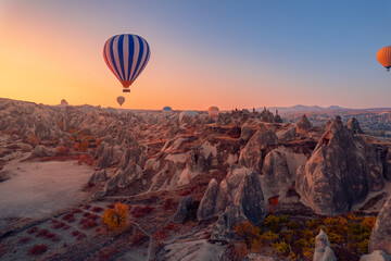 Fototapeta na wymiar Amazing sunrise Cappadocia with set colorful hot air balloons fly in pink sky with first sun light. Turkey travel Concept, aerial view