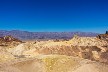Fototapeta na wymiar Badlands view from Zabriskie Point. Zabriskie Point is a part of the Amargosa Range located east of Death Valley in Death Valley National Park in California, USA.