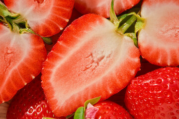 Half of a strawberry close-up on a wooden table, seasonal berry harvest, top view, idea for a strawberry background or making desserts