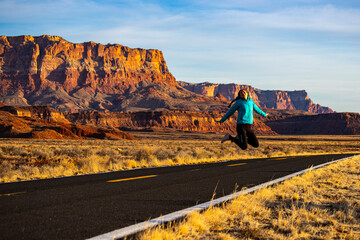 girl jumping for joy in the middle of nowhere in arizona, usa; girl lost in the american desert;...