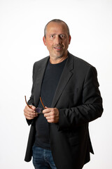 businessman in a casual suit holding glasses in his hands smiling at the camera