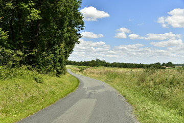 Route de campagne sous les cumulus de beau temps aux environs du bourg de Champagne au Périgord Vert  © Photocolorsteph