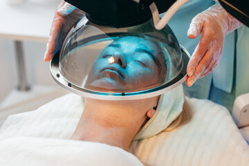 LED light facial therapy treatment for adult woman at modern cosmetology clinic