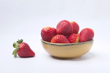 Yellow wooden bowl filled with strawberries.