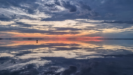 Fototapeta na wymiar Scenic view of beautiful water reflections in lake of Bonneville Salt Flats at sunrise, Wendover, Western Utah, USA, America. Dreamy clouds mirroring on the water surface creating romantic atmosphere