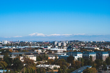 Fototapeta na wymiar View of Tashkent, the outskirts of the city, the country of Uzbekistan. View of the mountains and residential buildings from the window. Sunny day.