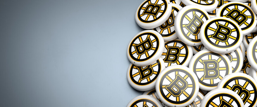 Logos of the American National Hockey League NHL Team Boston Bruins on a heap on a table.