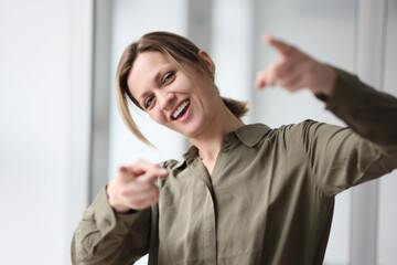 Portrait laughing woman showing index fingers, close-up