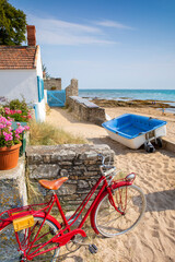 Vieux vélo rouge en bord de mer, sur l'île de Noirmoutier en Vendée, France.