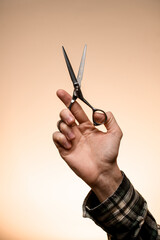 Hand of male barber hairdresser holds open scissors.