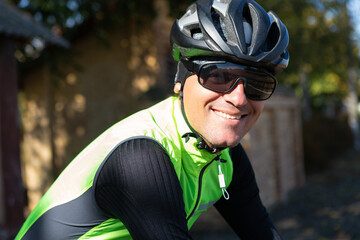 A man in clothes stands with a bicycle on an autumn sunny day. Cyclist in an urban environment.