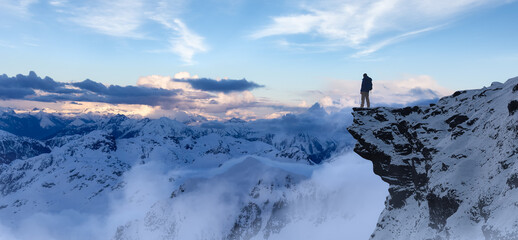 Adventurous Man Hiker standing on top of icy peak with rocky mountains in background. Adventure Composite. 3d Rendering rocks. Aerial Image of landscape from BC, Canada. Dramatic Sky