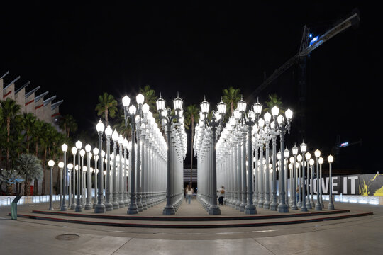 Los Angeles, United States - November 17, 2022: A picture of Urban Light, a public art designed by Chris Burden and unveiled in 2008, next to the Los Angeles County Museum of Art, at night.