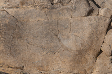 Brown textured stone background with real scratches and patterns. Stone wall is brown.