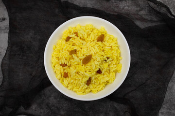Yellow rice with dried fruit in white bowl