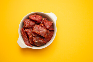 Fresh raw cube of beef in white bowl