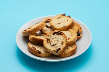 Mini round toasts of bread with raisins on dish