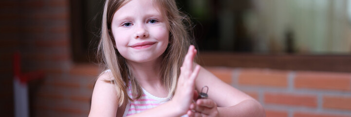 Little smiling girl prepares food in kitchen