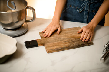 view on table with cutting board and female hands