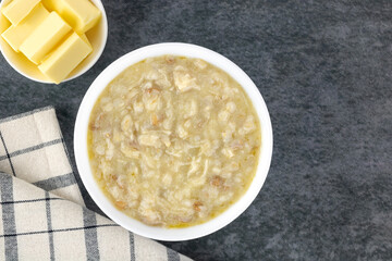 Armenian porridge - harissa with chicken and butter on gray background. Top view. Copy space. Armenian cuisine
