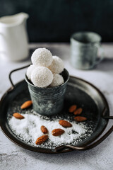 Beautiful and delicious homemade coconut flakes truffles with almonds and nuts in a retro grunge style.