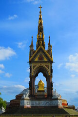 Albert Memorial in London with Royal Albert Hall behind and blue sky in summer