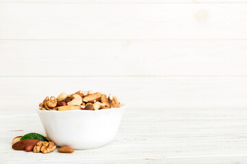 mixed nuts in bowl. Mix of various nuts on colored background. pistachios, cashews, walnuts, hazelnuts, peanuts and brazil nuts