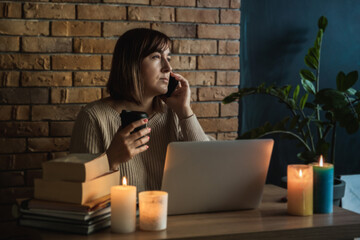 Young woman using laptop to work at home during electricity outage. Remote work at home concept....