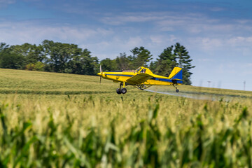 Yellow Crop Duster Spraying Pestisides On Crops