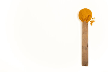 Turmeric in a wooden spoon.