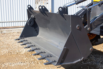 Construction road special transport - front loader. Metal dipper with teeth close-up.  © dore art