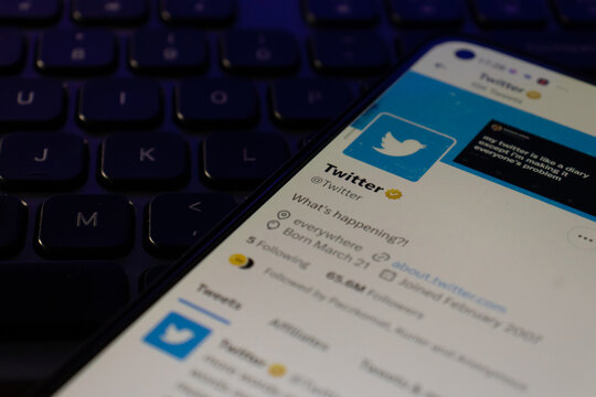 Smartphone with Twitter logo on the screen. Mobile phone is on lapop keyboard
