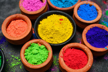 top view of colorful traditional holi powder in bowls isolated on dark background.Space for text . happy holi.Concept Indian color festival called Holi