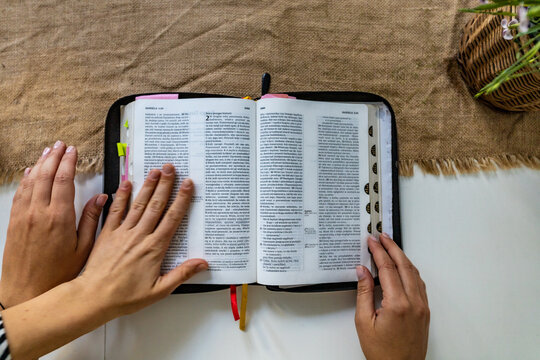 Reading Holy Bible with colorful highlights on pages which is lie on wooden table