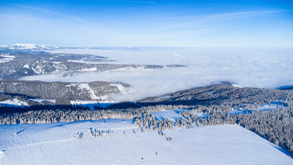 Fototapeta na wymiar Beautiful winter scenery seen from the air with blue sky and powder snow