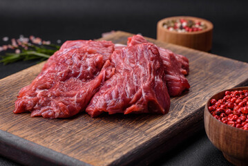 Raw beef cut into several pieces on a wooden cutting board