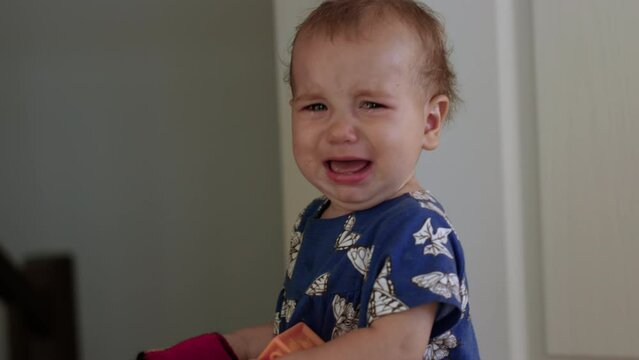 Very upset 1 year old girl cries with real tears over lost toy - medium shot