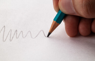 Draws a line on paper with a pencil. Close up. Macro