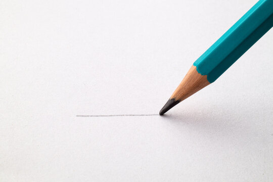 Draws a line on paper with a pencil. Close up. Macro