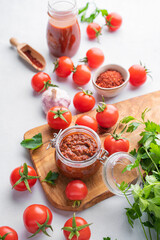 Salsa sauce is a traditional Mexican sauce with tomatoes and hot peppers on a light background with fresh herbs close up. Concept of a vegetarian food.