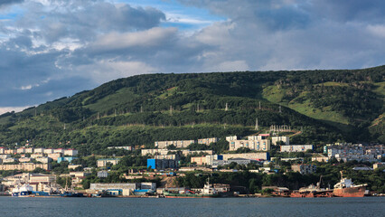 Fototapeta na wymiar The Pacific Ocean, ships, mountains, many houses on the mountain, clear sunny weather, Kamchatka.