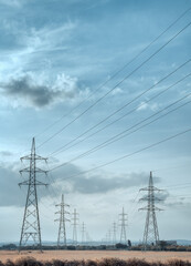 High voltage electricity towers under the sky. with cinematic look, in vertical 