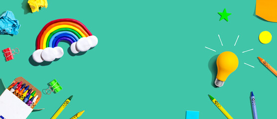 Idea light bulb with a rainbow and school supplies overhead view - flat lay