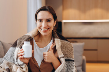Happy healthy woman recommending omega 3 fish oil and holding out a pill in her hand.