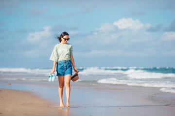 Young happy woman walking on the beach 