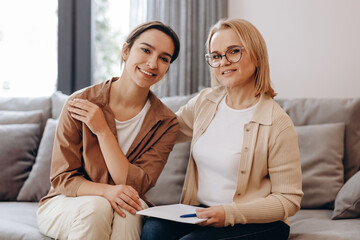 The girl came for a consultation with a psychologist, the psychologist and the client are looking at the camera and hugging.