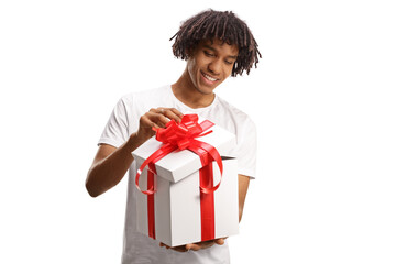 Happy young african american guy opening a gift box with red ribbon