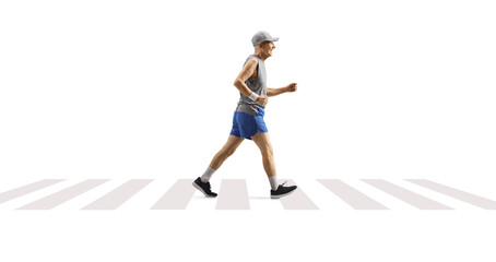 Full length profile shot of an elderly man jogging on a pedestrian crossing
