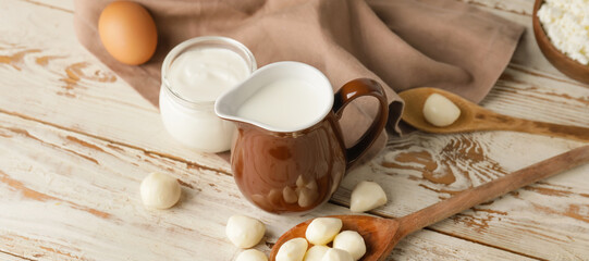 Different dairy products on white wooden background
